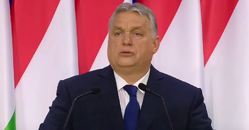Orbán Viktor, magyar zászló, fekete öltöny, kék nyakkendő, fehér ing
