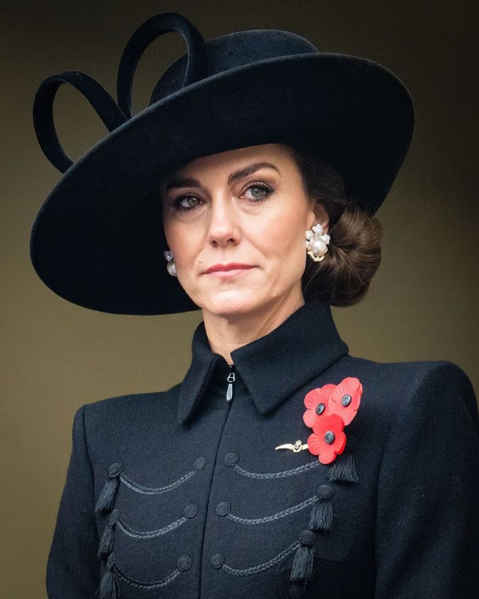 A képen oldalra néz fekete ruhába és kalapban Katalin hercegné.