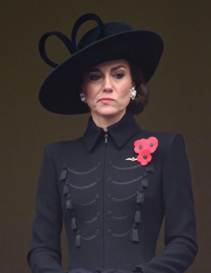 A képen Katalin hercegné fintorog fekete ünneplő ruhában és fekete kalapban. 
