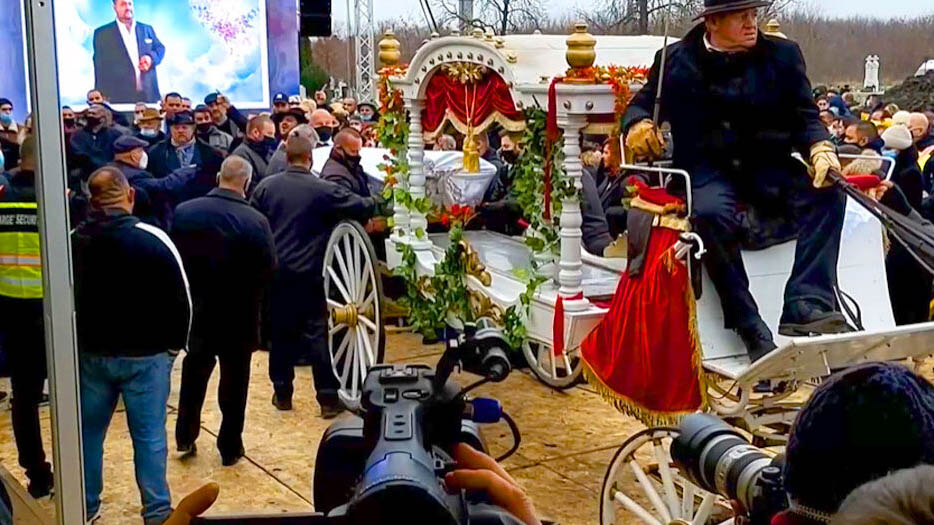 A kép egy ismert cigányzenész, Grófo temetésén készült, amelyen egy kivetítő, emberek és egy fehér hintó látható.