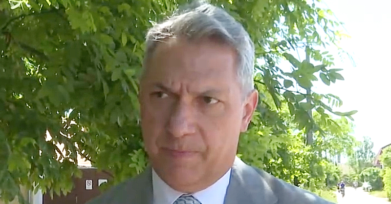 Lázár János zöld fa előtt szürke öltönyben, nyakkendőben néz a riporterre egy interjúban